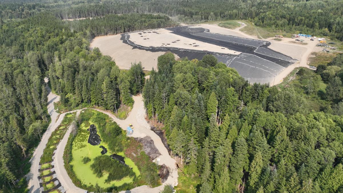 Aerial view of a lined landfill cell cut into forest